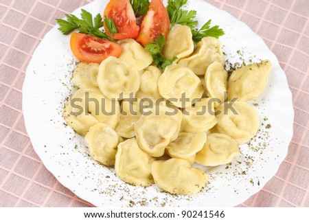 Pelmeni - traditional russian dish. Close up with tomato