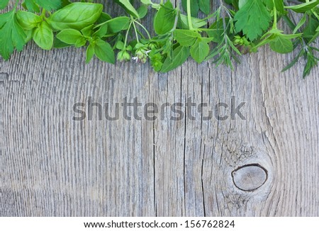 Parsley, oregano, basil on old wooden background