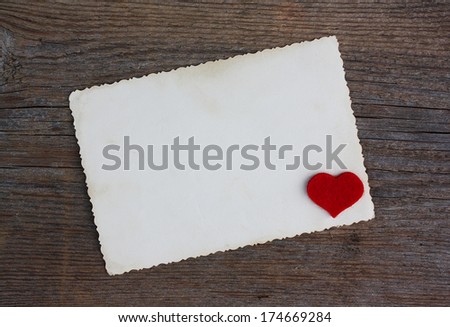 Empty paper form with red heart on old wooden background