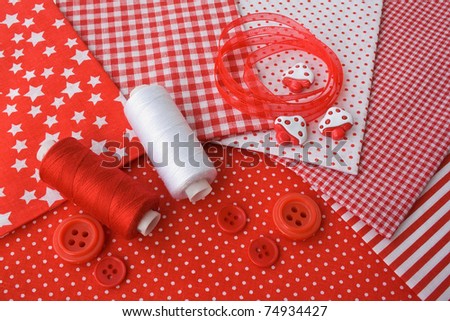 Accessories for sewing: threads, fabric, buttons in red-white color