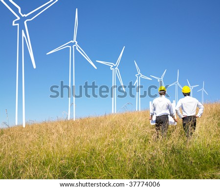 Engineers in field with plans building windmills
