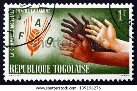 TOGO - CIRCA 1963: a stamp printed in Togo shows Hands Reaching for FAO Emblem, FAO Freedom from Hunger Campaign, circa 1963