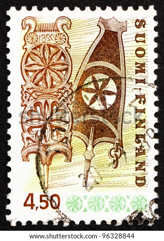 FINLAND - CIRCA 1976: a stamp printed in the Finland shows Carved Wooden Distaffs, circa 1976