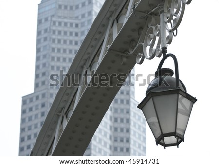 Old street light against a modern building isolated on white