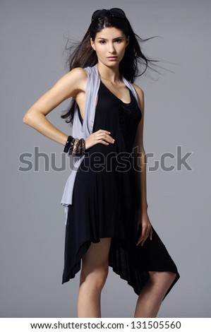 young woman in black clothing - studio shot on gray background