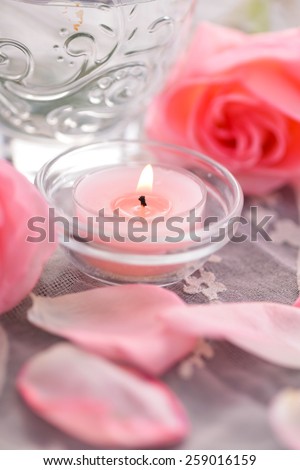 rose petals and rose with candle in bowl on lace