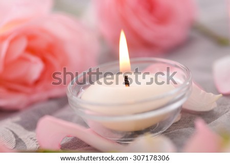 Pink rose petals and rose with candle on lace