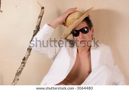 Young male fashion model with white clothes and soft hat