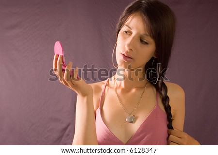 Young brunette girl dressed holding mirror