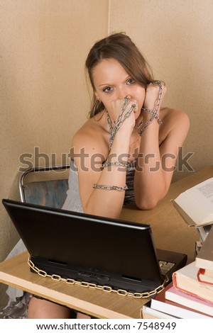 Young business woman at office with laptop linked with chain