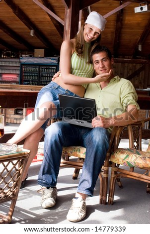 Young man and woman in restaurant with laptop