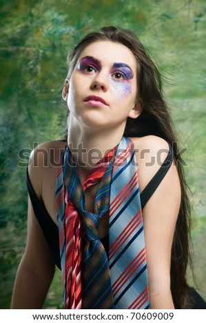 Young woman with disorderly stack in layers of make up on face and neckties around her neck