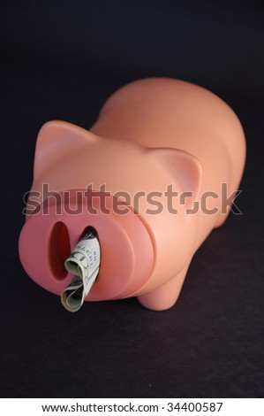 Dollar bill sticking out of a plastic pigs snout.  Works for many concepts involving saving money, spending money, wasting money, etc.