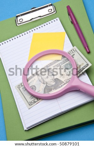Magnifying glass analysis of business or education costs.