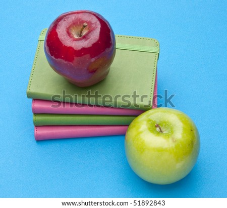 Health Care or Education Themed Image with Books and Apples on a Bright Blue Background.