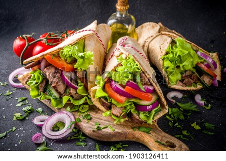Turkish kebab wrap shawarma  sandwiches. Tasty fresh wrap sandwiches with beef meat and vegetables, Traditional Middle Eastern snack.