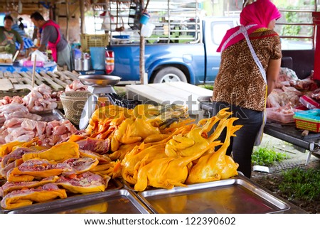 KHAO LAK, THAILAND - NOV 05: Unidentified woman selling chicken meat on the local market in Khao Lak. This market is also tourist attraction in Phang Nga province, Thailand on Nov.05, 2012.