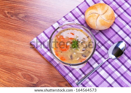 Mushroom soup with bread roll on the table