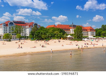 SOPOT, POLAND - 7 JUNE: People on the beach of Sopot at the Grand Hotel on 7 June 2014. Grand hotel built in 1924-1927 is the most refined hotel in Sopot - major health and tourist resort destination.