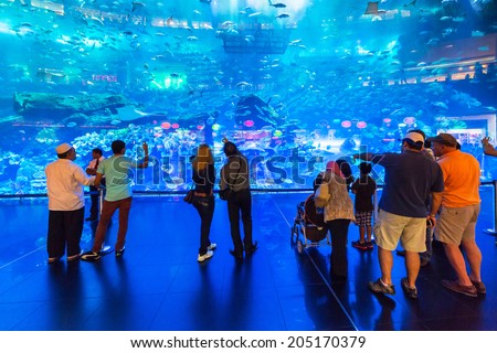DUBAI, UAE - 1 APRIL 2014: People in front of the Oceanarium inside Dubai Mall. It is the largest indoor aquarium in the world at a length of 50 meters long and 10 million litres of water.