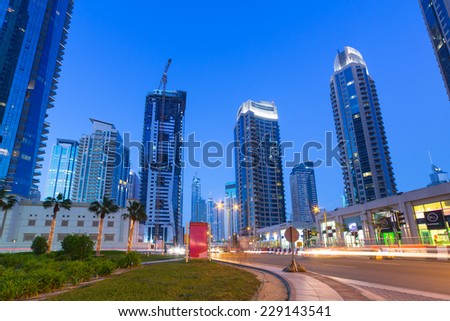 DUBAI, UAE - MARCH 30, 2014: Illuminated skyscrapers of Dubai Marina at night, United Arab Emirates. Dubai Marina is a district with artificial canal city who accommodates more than 120,000 people.