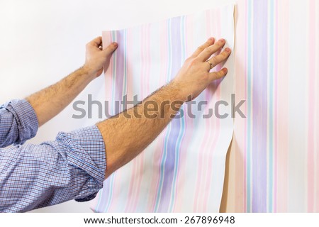 Man putting up wallpapers
