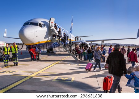 GDANSK AIRPORT, POLAND - 10 APRIL 2015: People boarding to Ryanair plane on Lech Walesa Airport in Gdansk. Ryanair operates over 300 aircraft and is the biggest low-cost airline company in Europe.