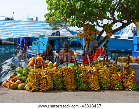MALE - JULY 1: Three street vendors sit by bananas stall - Market situated on the harbor of Male - capital of Maldives - July 1, 2009 - Male - Maldives.