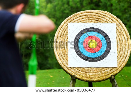 An archer with bow takes aim at target