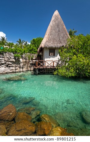 Idyllic mexican jungle scenery with hut on the water