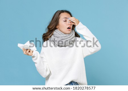 Sick young woman in white sweater scarf hold napkin put hand on nose keeping eyes closed isolated on blue background studio portrait. Healthy lifestyle ill sick disease treatment cold season concept Zdjęcia stock © 