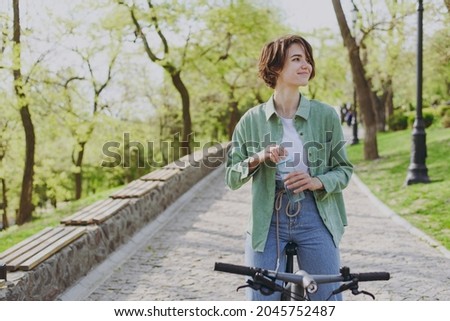 Image, Stock Photo Woman with bicycle walking in park