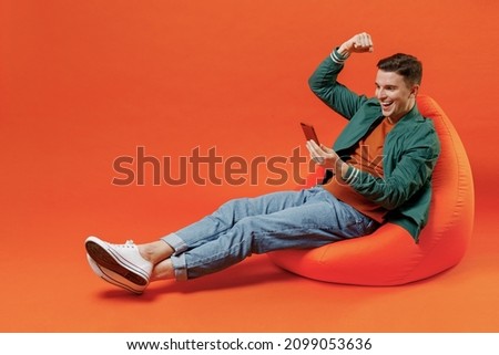 Image, Stock Photo Young man holding a small plant of cactus with his left hand. He’s in the center of the image. The background is yellow. The cactus is inside a brown vase