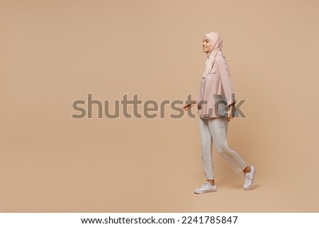 Similar – Image, Stock Photo Young Arab woman walking in the street using her smartphone