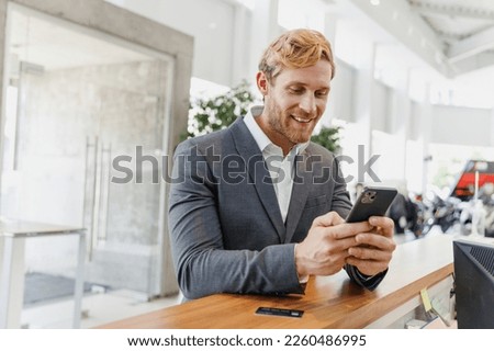 Man businessman happy male client in classic suit standing at office table look aside use mobile cell phone credit bank card in dealership salon store office indoors Business lifestyle sales concept Photo stock © 
