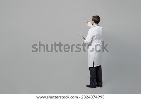 Full size male doctor happy cheerful man wears white medical gown suit work in hospital hold clipboard with paper documents isolated on plain grey color background studio. Healthcare medicine concept Stockfoto © 