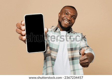 Similar – Image, Stock Photo Young black man holding wireless headphones while wearing a white sweatshirt, against a blue wall looking away with confidence. Selective focus