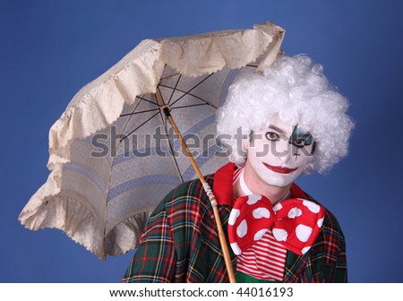 funny clown with white hair and umbrella on blue background