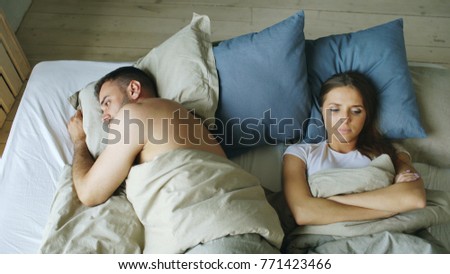 Top view of upset lying sleepless couple in bed offended because of quarrel Foto stock © 
