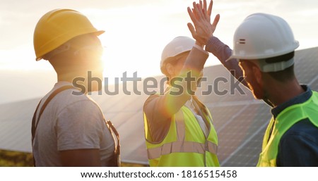 Happy employees of solar power plant raise their hands and shout for joy, clapping each other. People are satisfied with result of their work success. Foto stock © 