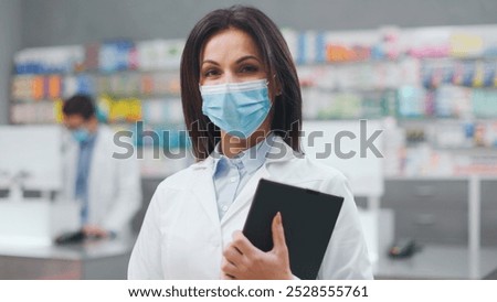 Similar – Image, Stock Photo Concentrated female cashier in face mask working with cash till