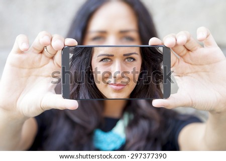 pretty woman with gray eyes take a selfie with smart phone