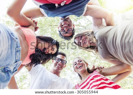 group of smiling friends in circle - bottom view