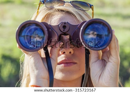 pretty girl with binoculars looking at the horizon
