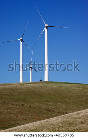 Three wind turbines stand ready for the wind