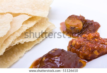 Traditional indian hors d\'oeuvres of popadom and spicy pickles.