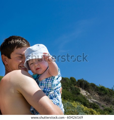 Young Father and 2-3 month old baby son at beach for first time.