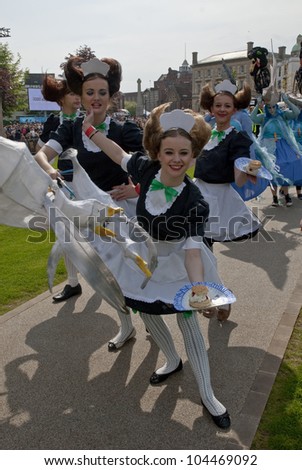 EXETER - MAY 18: Performers dresses as waitresses serve cakes on Exeter Cathedral Green as part of the Battle for the Winds Parade on May 18, 2012 in Exeter, UK