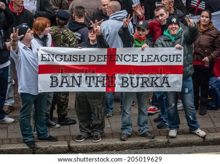 EXETER, UK - NOVEMBER 16: English Defence League members hold up a 'Ban the Burka' banner during the English Defence League march and rally November 16, 2013 in Exeter, Devon, UK