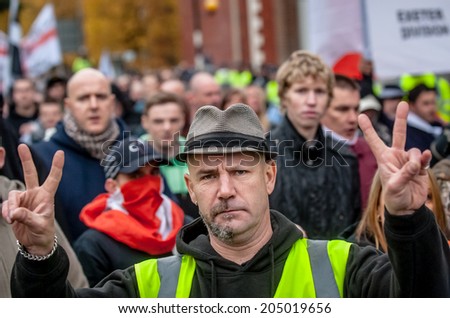 EXETER, UK - NOVEMBER 16: English Defence League member gives a victory sign during the English Defence League march and rally November 16, 2013 in Exeter, Devon, UK